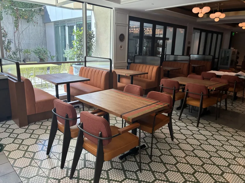 Upholstered banquettes, dining chairs, and tables beside the windows at Birdie G's.