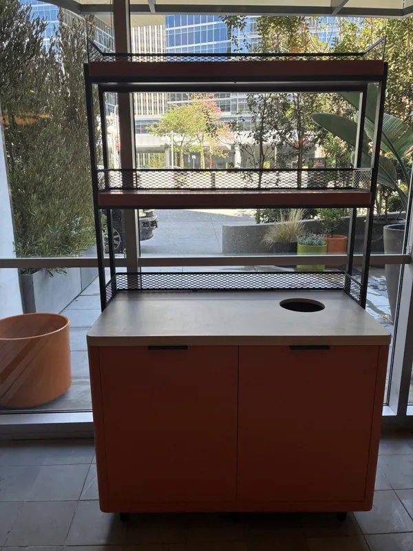 A cabinet and open shelving positioned beside the window at Birdie G's.