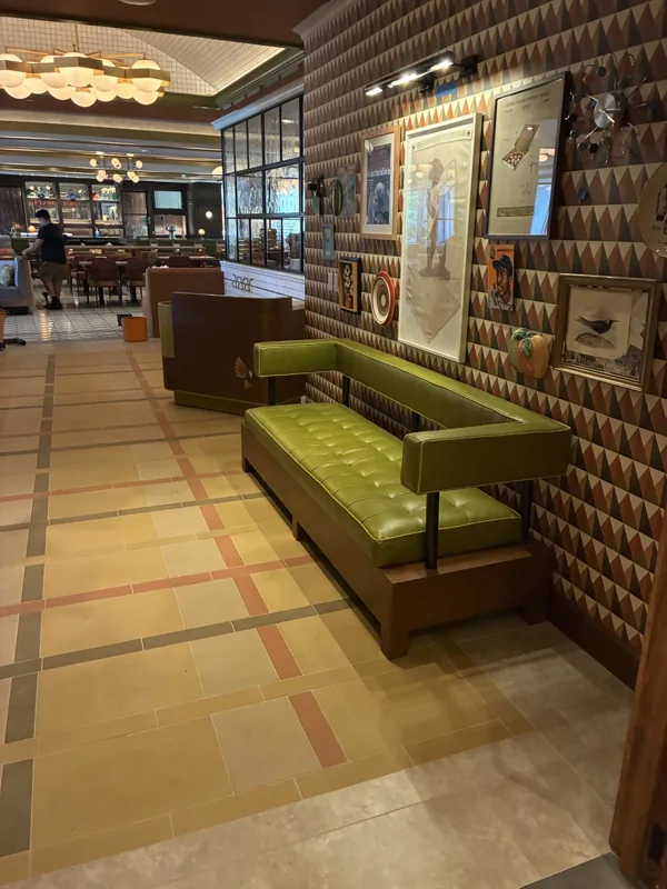 Green upholstered seating along the patterned entrance wall at Birdie G's.