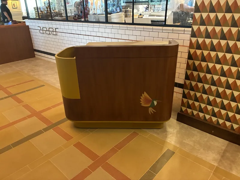 The curved front and yellow accent of the welcome station at Birdie G's.