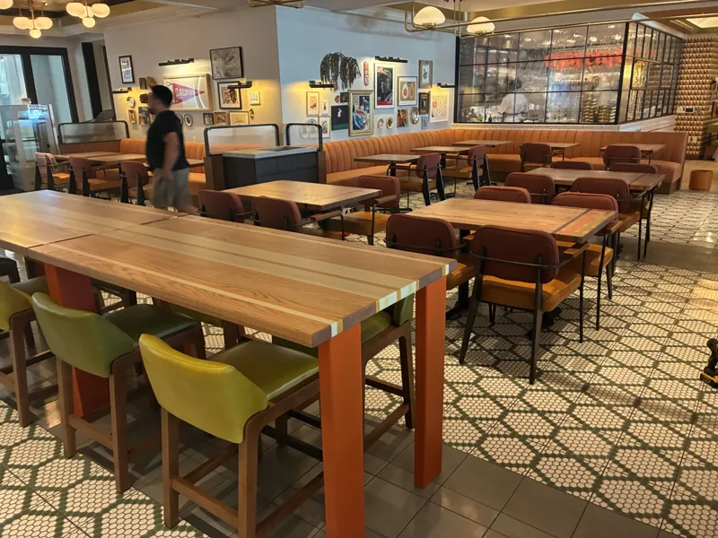 The shared table, green stools, and surrounding dining room at Birdie G's.