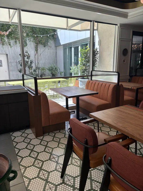 A closer view of the banquette, chairs, and tables beside the windows at Birdie G's.