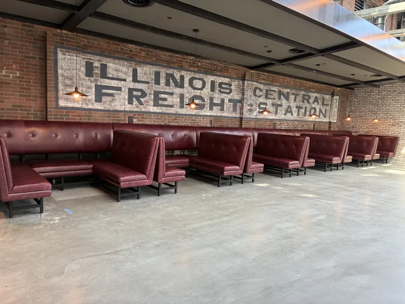 Burgundy booths arranged beneath the Illinois Central Freight Station sign.